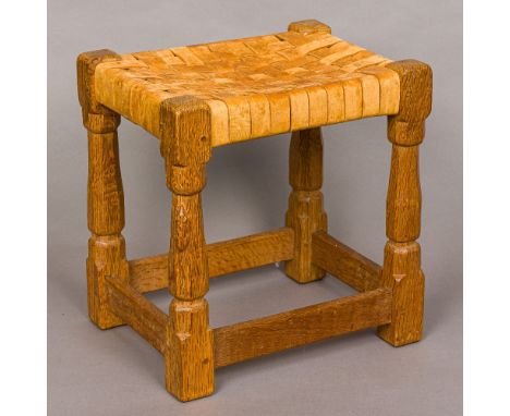 ROBERT MOUSEMAN THOMPSON of KILBURNAn adzed oak stool with a tan lattice work seat, with carved mouse signature.  34 cm wide.