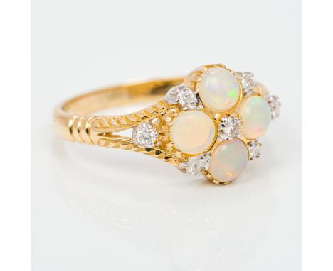 A 9 ct gold diamond and opal set ringThe four cabochon opals surrounded by seven small diamonds.  1 cm high.  CONDITION REPOR