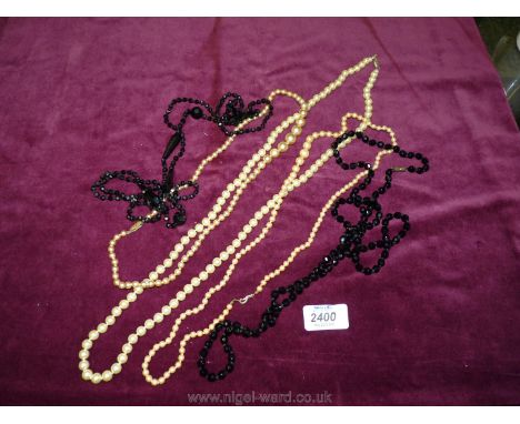 Two jet necklaces and three simulated pearl necklaces.
