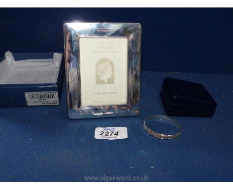 A silver Golden Jubilee picture frame, Birmingham and a white metal expanding christening bangle, both boxed.