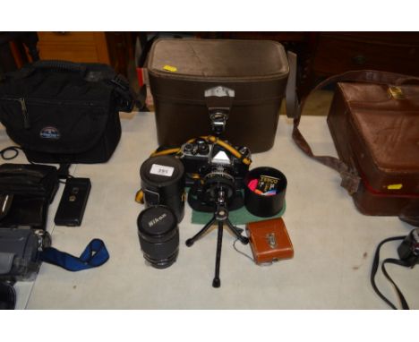 A Nikon FE2 camera with small tripod stand, carrying bag, a Nikon lens etc.