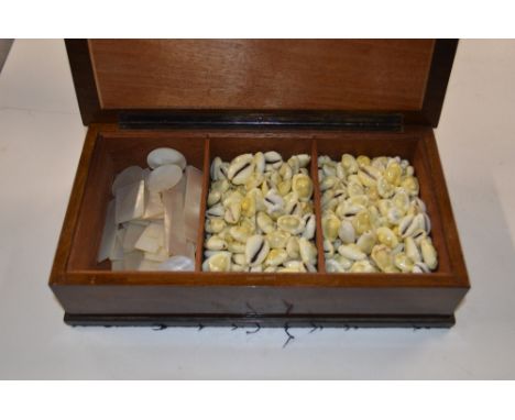 A wooden box of shells and mother of pearl counters