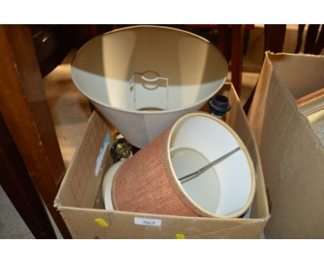 A box containing table lamp bases and shades