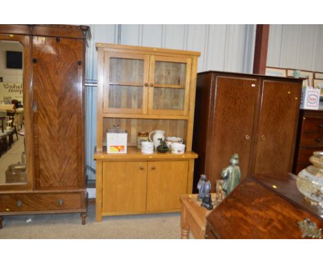 A light oak and glazed dresser raised on cupboard base