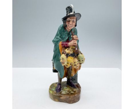 Modeled with a green cape and a black hat, carrying a display of yellow mask on the front and a lantern and bags at his back.