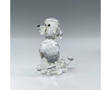 This poodle figurine features a clear crystal head and body, with black eyes and nose. Its tongue, front feet, and a section 
