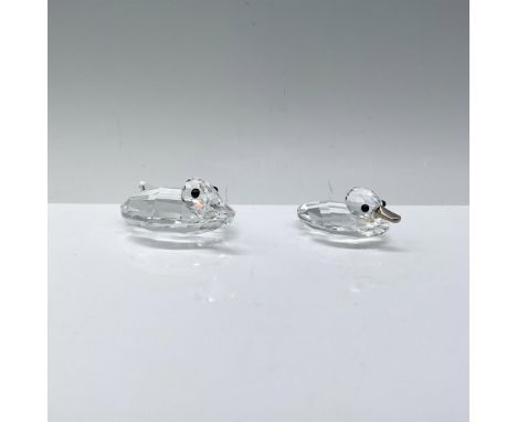 A pair of clear crystal ducks, gracefully swimming with sleek black crystal eyes and delicately crafted crystal or metal beak