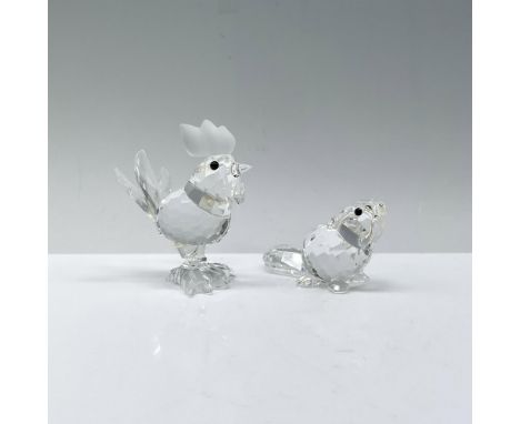 A clear crystal rooster (014497) standing proudly, and a baby beaver (164638) gazing up in wonder, both adorned with striking