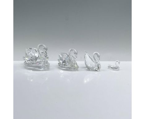 A set of four clear crystal swans, that includes 010005, 010006, 189254, and 010021 elegantly gliding in a swimming pose, eac