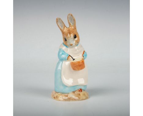 Modeled with a blue dress and white apron. This item has its original box measuring 3"L x 3"W x 4.25"H. Royal Albert backstam