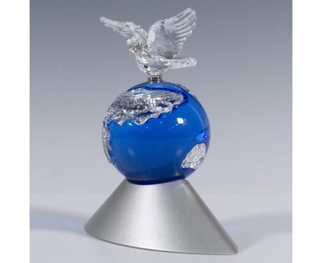 A stunning sapphire blue globe with clear crystal continents. A clear crystal dove carrying an olive branch is perched atop t