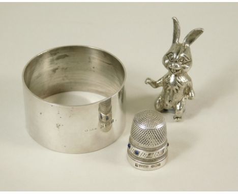 NAPKIN RING. A silver napkin ring, a silver thimble (some missing stones) &amp; a silver novelty rabbit.