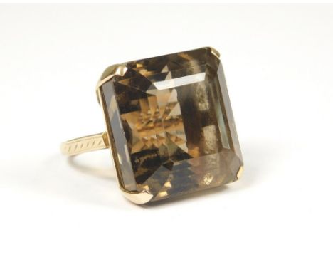 DRESS RING. A very large yellow metal ring, set a large step-cut smoky quartz. Size K/L.