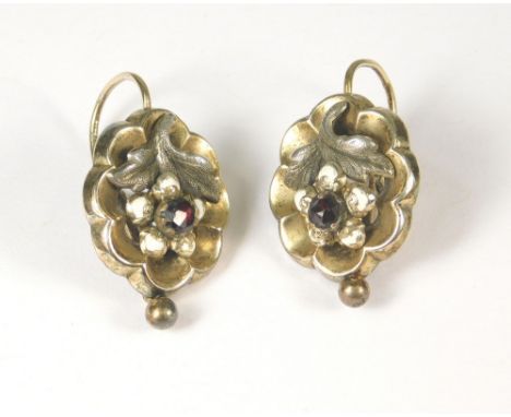 VICTORIAN EARRINGS. A pair of Victorian earrings, each front set a red stone & with white enamel petals.