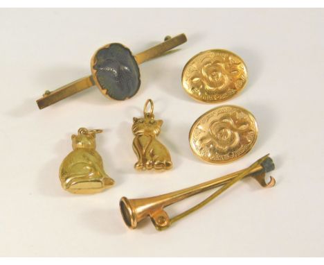 SCARAB PIN ETC. A 9ct. gold stock pin mounted a scarab, a rolled gold hunting horn pin, two cat charms etc.