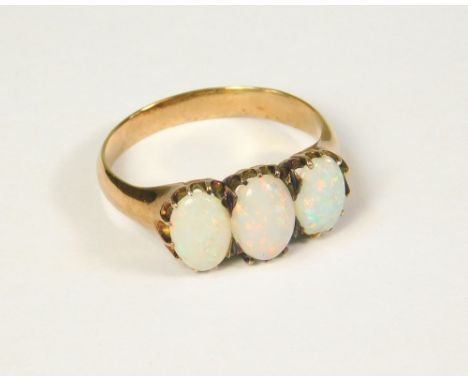 OPAL RING. A three stone opal ring, set in unmarked yellow metal. Size O.