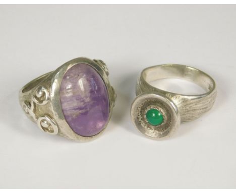 SILVER RINGS. Two silver rings hand made by John Simpson (St. Ives). One set with amethyst &amp; the other, a green agate. Ap
