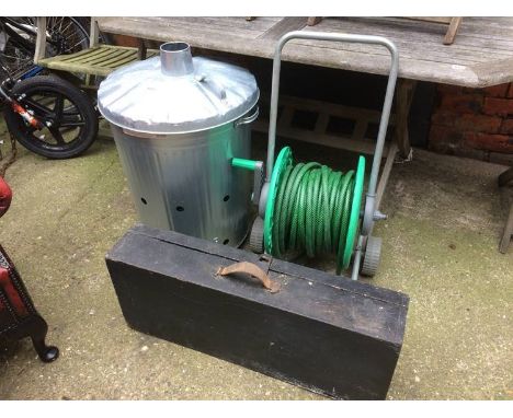 Garden incinerator together with a roll up hose pipe
