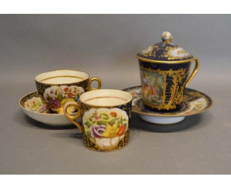 A French Porcelain Covered Chocolate Cup with stand, hand painted with summer flowers upon a dark blue ground highlighted wit