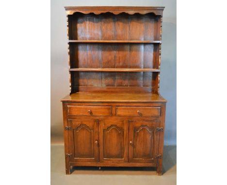 A George III Style Oak Dresser, the boarded shelf back above two drawers and two arched panel doors with central panel flanke