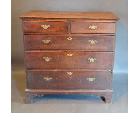 A George III Oak Chest, the star inlaid and moulded top above two short and three long drawers with brass handles and escutch