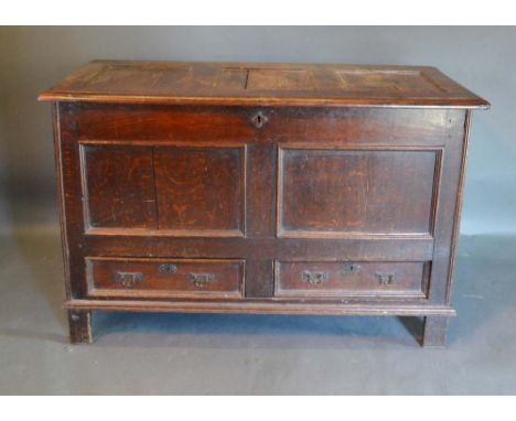 A George III Oak Mule Chest, the hinged top above a two panel front and two drawers flanked by stiles, 121cm wide, 52cm deep,
