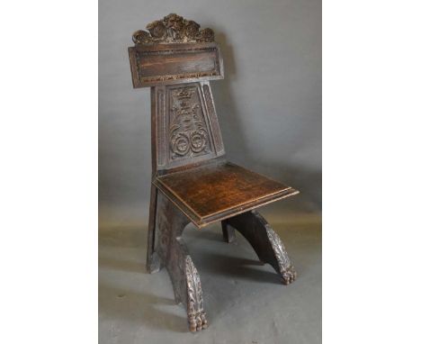 A Victorian Carved Oak Hall Chair, the carved lion mask back above a panel seat raised upon carved paw feet bearing label Tra