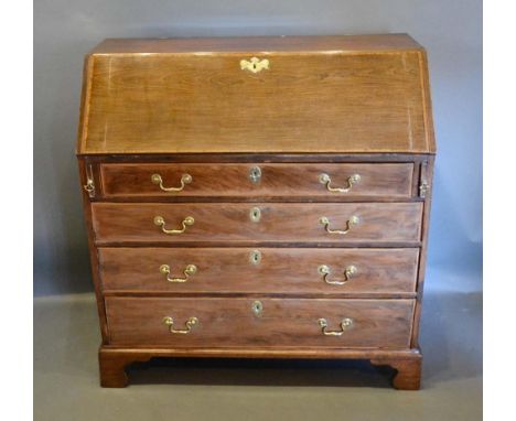 A George III Mahogany Bureau, the fall front enclosing a fitted interior above four long graduated drawers with brass handles