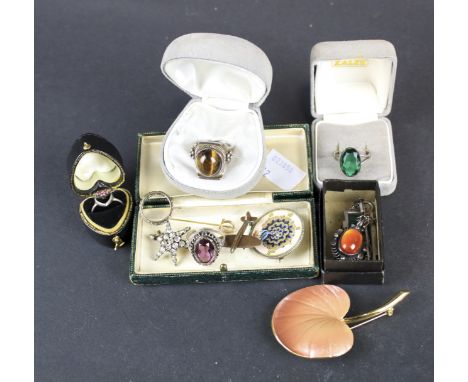 An assortment of jewellery. Including a white metal pendant and chain, white metal rings, an enamel brooch modelled as a leaf