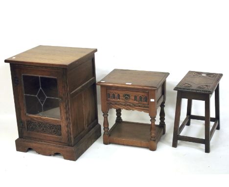 An oak side cabinet, a single drawer oak side table and an oak stool. The cabinet with a single glazed door opening to reveal