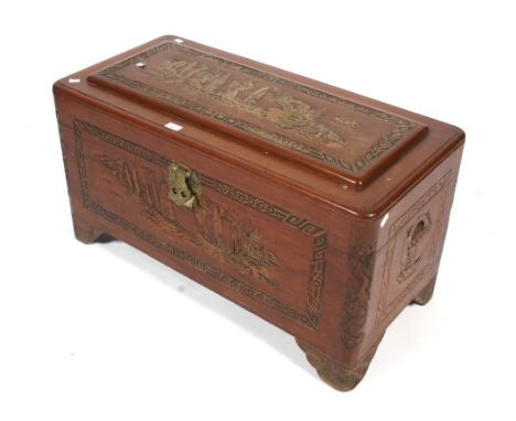 A 20th century camphor wood trunk. All sides with heavily carved Chinese style decoration, including a landscape scene to the