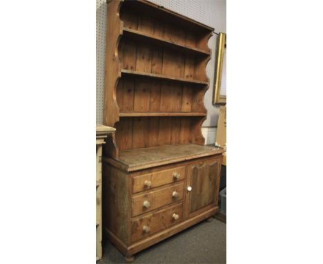 A 20th century pine kitchen dresser. The upper section with three plate racks, the lower section with three graduated drawers