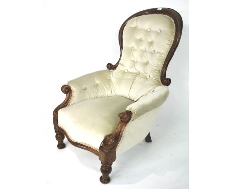 A Victorian button back armchair. The mahogany frame with scroll details, upholstered in cream fabric, raised on turned suppo