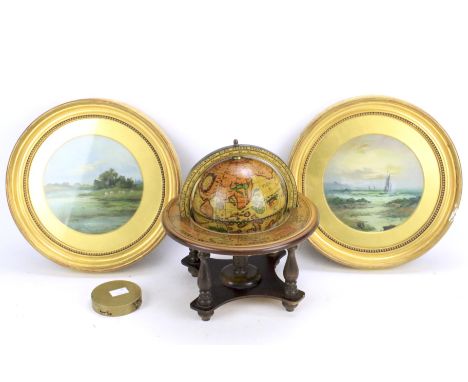 A pair of oil on boards, a globe and a brass compass. The paintings of circular form, depicting a seascape and riverside scen