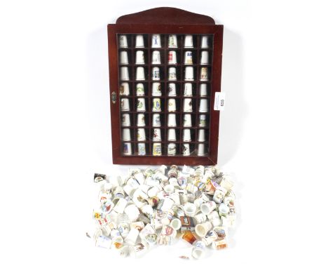 A large collection of thimbles. Mostly ceramic examples, together with a collectors display cabinet