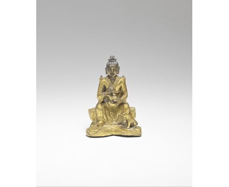 A RARE GILT-BRONZE FIGURE OF SUN SIMIAO18th centuryExpertly cast as a bearded scholar seated on rockwork holding an ewer in h