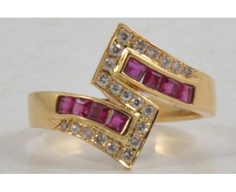 A ruby and diamond crossover ring, the yellow metal mount marked 18K 750 set with eight square cut rubies and twenty-one bril