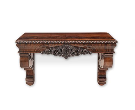 A William IV mahogany wall-mounted console or pier table1830-1840The top with a gadrooned edge above an ogee frieze with cent