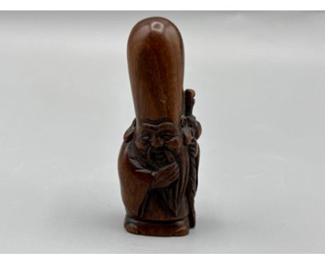 Hand carved Japanese Netsuke in the form of a village elder, signed on base, H6cm