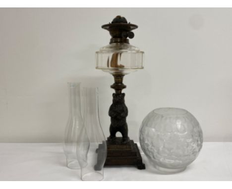 Vintage oil lamp with cast metal bear and base, damage repair to globe split wick - height 45cm