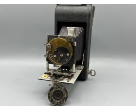 Vintage folding pocket bellows camera (possibly Kodak) together with a Kodak ball bearing shutter