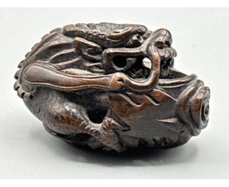 Japanese hand carved boxwood Netsuke in the form of a Foo Dragon, signed on base, L6cm x H3.5cm