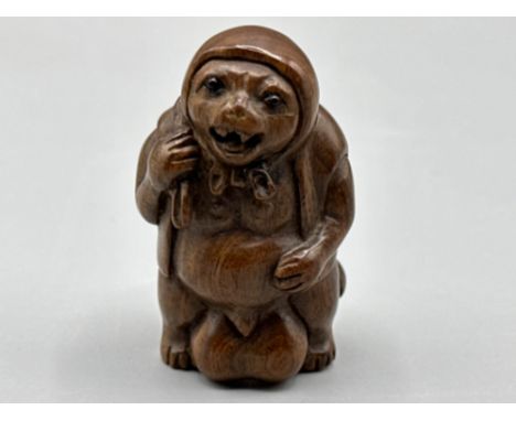 An unusual Japanese hand carved Fertility Netsuke in the form of an animal/villager, H3cm x W4cm