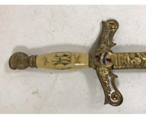 AN AMERICAN SOCIETY SWORD &amp; SCABBARD. Having a gilt knights helmet pommel, with white ivorine grip decorated with masonic