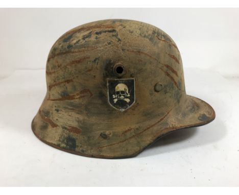 A GERMAN MILITARY HELEMT, PROBABLY SECOND WORLD WAR. A German helmet with leather liner and chin strap, indistinctly marked, 