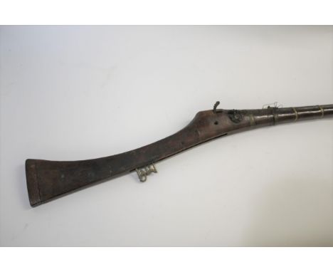 EASTERN MATCHLOCK LONG GUN a decorator long gun with matchlock mechanism, with brass barrel bands. Gun 60ins long, Barrel 41i