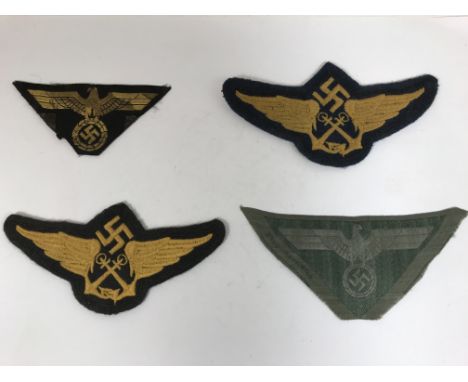 FOUR GERMAN CLOTH BADGES. Two cap insignia with crossed anchors beneath a swastika and between wings for Marine Fliers, Civil