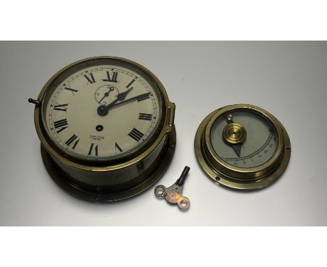A Smith's Empire brass ships clock with metal dial and black roman numerals nd smaller seconds subsidiary dial with key (h-18
