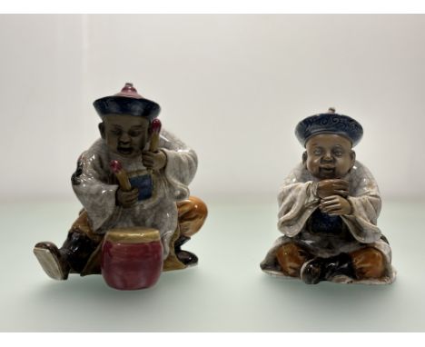 A pair of Chinese porcelain young muscians, one crouched playing the drums (h-21cm), the other playing a wind instrument (h-1