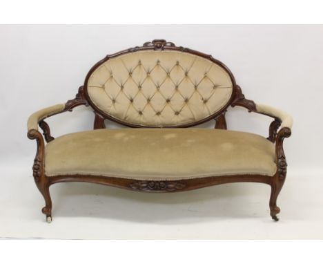 Victorian mahogany framed settee, with button upholstered tablet back and seat in carved showroom frame on cabriole legs and 